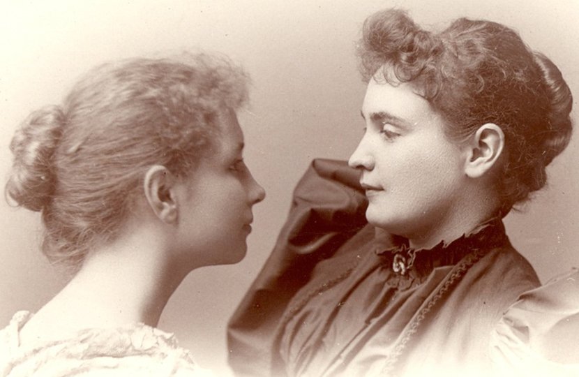 Helen Keller and her teacher Anne Sullivan standing face to face.
