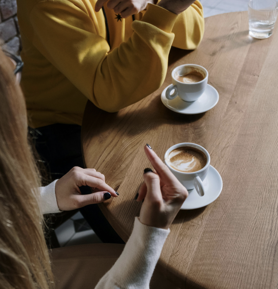 Two people sit down for coffee and are signing. Ginny & Georgia casts Deaf actor Chris Kenopic and uses American Sign Language through out the show.
