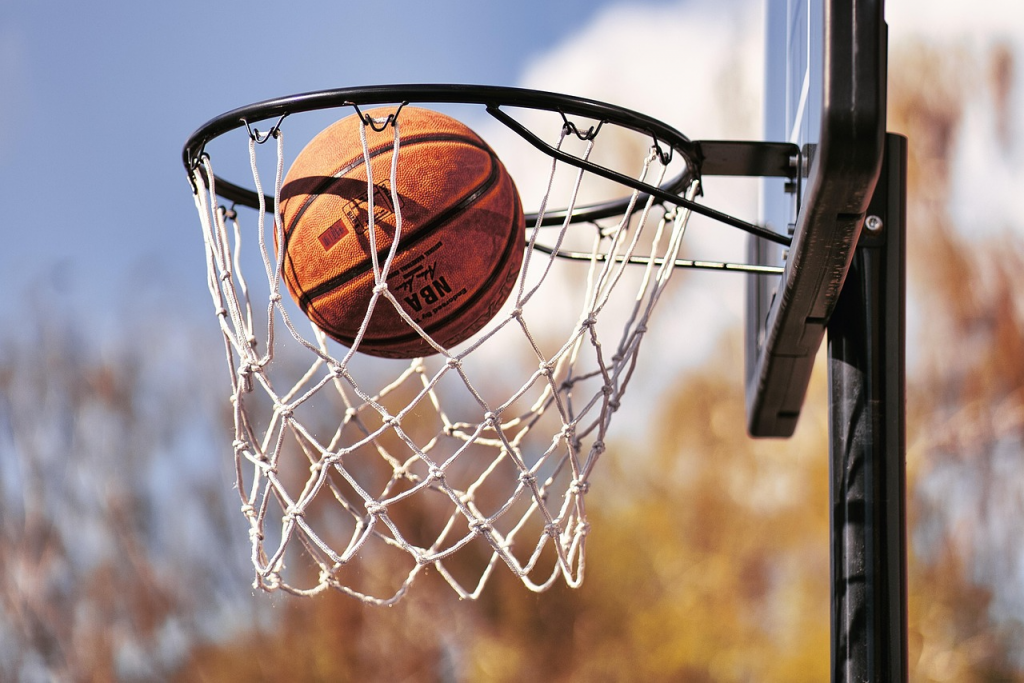 A basketball is thrown into the a basketball hoop with clear skies in the background. Carter Bryant is a GODA who is now playing in the NBA.